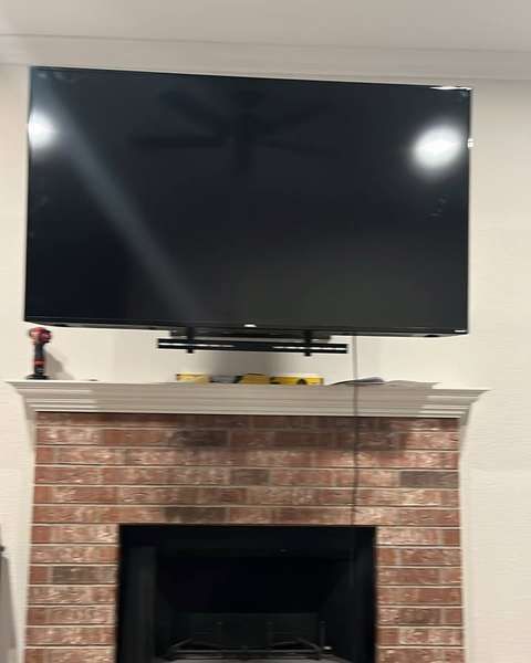 TV above a red brick fireplace
